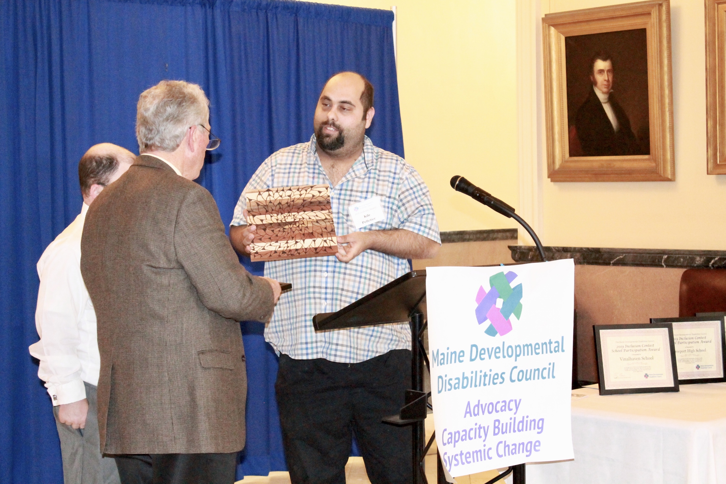 Kile Pelletier hands an award to a State Representative at the 2019 Inclusion Awards